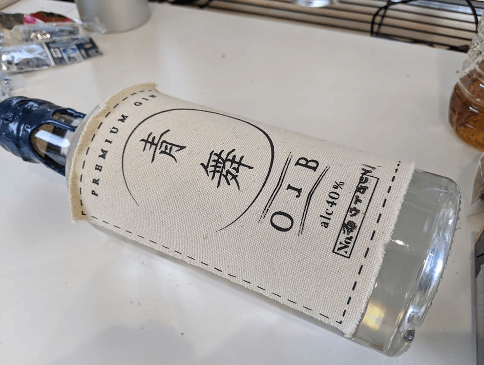 Japanese craft spirit bottle beside a presentation box.