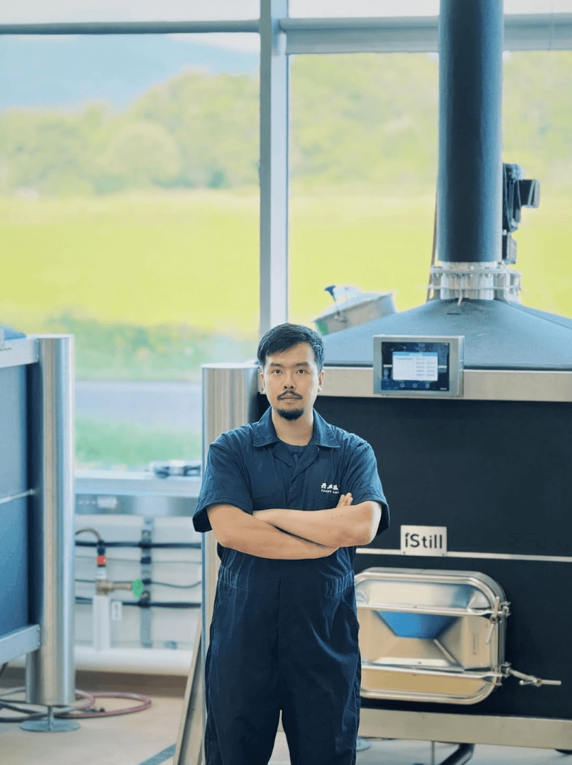 Tankyu Distillery team member standing in front of iStill production equipment.