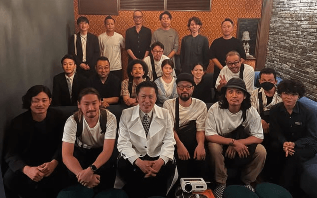 Japanese distilling team gathered together indoors.