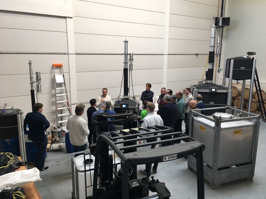 The class gathers around the equipment for a practical demonstration.